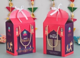 Premium Diwali hamper box with nuts, dragees, tea, date bites, energy bars & decorative candle in festive packaging