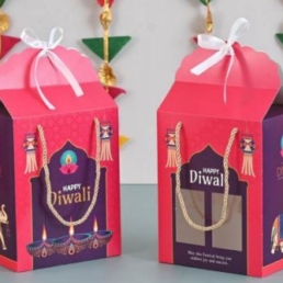 Premium Diwali hamper box with nuts, dragees, tea, date bites, energy bars & decorative candle in festive packaging